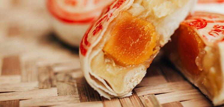 Bánh pía 朥饼 hay còn gọi là Bạch thoại tự: hó-piáⁿ là món bánh ngọt ngàn lớp có nhân và là bánh trung thu truyền thống xuất phát từ Triều Châu, Trung Quốc và được du nhập vào các khu phố người Hoa trên thế giới. Đặc biệt ở Đông Nam Á, nơi có Hoa Kiều cư ngụ là Malaysia, Indonesia, Philippines và Singapore. Ở Indonesia, bánh có tên gọi là Bakpia Pathok. Tại Việt Nam, bánh pía là một trong những đặc sản của Sóc Trăng, do người Hoa di cư vào miền Nam sáng tạo ra.  Những chiếc bánh pía nguyên thủy chỉ có nhân thịt heo và đậu xanh, loại bột bánh có nhiều lớp mỏng và nhân bánh có trộn mỡ. Từ pía có gốc từ tiếng Triều Châu “pi-é”, âm Hán Việt có nghĩa là bánh.  Bánh pía 朥饼 ngày trước cũng khá đơn giản, vỏ ngoài làm bằng bột mì có nhiều lớp da mỏng bao lấy phần nhân, lớp da ngoài dày thường để in chữ, nhân làm bằng đậu xanh và mỡ heo chứ không có lòng đỏ trứng muối và các loại thành phần khác như hiện nay. Do thị hiếu của người tiêu dùng mà các lò bánh mới thêm các thành phần hương liệu khác như sầu riêng, khoai môn, lòng đỏ trứng muối.  Nguyên liệu làm Bánh pía 朥饼: Bột mì đa dụng: 400 gram Đậu xanh: 250 gram Đường cát trắng: 300 gram Thịt sầu riêng: 200 gram Nước lọc: 220 ml Bột năng: 100 gram Mỡ lợn: 300 gram Dầu thực vật: 145 ml Mạch nha: 15 gram Trứng: 12 quả (lòng đỏ trứng muối) Baking power: 4 gram (bột nở) Màu đỏ thực phẩm: 1/4 muỗng cà phê  Dụng cụ thực hiện: Nồi, lò nướng, chén, muỗng, đũa, thau...  Cách chế biến Bánh pía 朥饼: Làm phần bột nước (bột vỏ):  - Trộn đều 300 gram bột mì và 2 gram bột nở vào trong một chiếc chậu nhỏ hoặc thau nhỏ, đừng quá lớn rất khó để nhồi.  - Cắt nhỏ 200 gram mỡ lợn và cho vào chảo thắng với lửa vừa để lấy nước mỡ. Thắng đến khi mỡ teo lại thành tốp nhỏ vàng ươm thì tắt bếp, vớt bỏ tốp mỡ hoặc ta có thể để lên và làm ra các món ăn khác từ nó.  - Sau đó vun bột thành một cái núi nhỏ, khoét một lỗ ở giữa núi bột và cho 40 gram đường cát trắng, 120 ml nước sạch, 50 ml dầu thực vật và 50 ml mỡ nước vào (tỉ lệ 1:1 giữa dầu thực vật và mỡ).  - Dùng tay nhào trộn nguyên liệu quyện vào nhau để tạo thành một hỗn hợp bột dẻo. Để bột nghỉ khoảng 30 phút, sau đó cân và chia bột thành 12 phần bằng nhau.  Mách nhỏ:  Có thể thay mỡ nước bằng dầu thực vật. Phần bột trộn xong sẽ tương đối ẩm, nhiều dầu nhưng không nhão. Làm phần bột dầu cho bánh pía 朥饼 (bột ruột):  - Cho 100 gram bột mì, 100 gram bột năng và 2 gram bột nở vào bát sau đó dùng tay trộn bột đều lên, nếu dính có thể cho thêm ít bột để đỡ dính. Nhớ đừng cho nhiều quá sẽ làm dai bánh.  - Tiếp tục cho 20 gram đường cát trắng, 35 ml mỡ nước, 100 ml nước và 45 ml dầu thực vật vào hỗn hợp bột khô và trộn đều trong khoảng 5 phút đến khi cảm thấy hỗn hợp bột quyện đều vào nhau, dẻo và mịn.  - Để bột nghỉ 30 phút. Sau đó cân và chia bột đều ra làm 12 phần bằng nhau. Lưu ý, phần bột này khá ẩm và hơi nhão.   Làm phần nhân bánh Pía 朥饼: Chế biến mỡ lợn:  - Đem 100 gram mỡ lợn rửa sạch, cắt hạt lựu rồi đem luộc chín. Cho ít muối vào để loại bỏ bớt các chất dơ bám xung quanh.  - Vớt phần mỡ sau khi luộc ra để ráo rồi trộn với 60 gram đường cát trắng. Để hỗn hợp mỡ đường ra chỗ nắng cho mỡ trong lại.  - Chế biến trứng muối: Lòng đỏ trứng muối xả sạch dưới vòi nước rồi đem ngâm với rượu trắng trong 15 phút. Sau đó lấy ra hấp chín.  Chế biến đậu xanh cho phần nhân bánh pía 朥饼:  - Cho 250 gram đậu xanh bỏ vỏ, ngâm nước cho mềm (tốt nhất là bạn nên ngâm từ 7 đến 8 tiếng) vào nồi, đổ nước ngập trên mặt đậu 1 đốt ngón tay.   Lưu ý: Khi ngâm đậu xanh qua đêm sẽ làm cho chúng ngon hơn khi làm bánh.  - Đun đến khi đậu chín mềm. Trong quá trình đun hớt bọt cho sạch và để bánh thơm hơn.  - Cho đậu chín vào máy xay sinh tố và xay (xay khô không thêm nước) cho đậu nhuyễn mịn. Tránh xay không nhuyễn làm nhân sẽ bị cục gây không ngon.  Và tiếp theo ta sên đậu xanh:  - Cho chảo chống dính lên bếp, để lửa to để chảo nóng đều. Sau đó chuyển sang lửa vừa, cho đậu xay nhuyễn vào chảo và xào với 180 gram đường.  - Trong quá trình sên đậu, cho dầu ăn vào hỗn hợp nhiều lần. Sên đến khi đậu trở nên trong, dẻo thì cho 200 gram sầu riêng say nhuyễn và 100 gram mỡ đường vào xào cùng.  - Sên với lửa thật nhỏ để tránh tình trạng tách dầu, làm hỏng nhân bánh.   - Khi hỗn hợp đã trong, dẻo và không còn dính chảo nữa thì cho 15 gram mạch nha vào và trộn đều. Để hỗn hợp nhân thật nguội rồi chia thành 12 phần bằng nhau.   - Lấy mỗi phần nhân bọc lấy 1 lòng đỏ trứng muối rồi vo tròn lại.  Mách nhỏ:  Bạn cũng có thể đánh bằng tay nếu như nhà không có máy xay khô, đánh thật kỹ đến khi đậu nhuyễn mịn là được. Khi xào nhân bánh, bạn có thể tăng giảm gia vị cho vừa khẩu vị. Nếu nhân bánh còn hơi nhão thì bạn cho thêm bột nếp rang vào và trộn đều. Sên 1 chút cho nhân dẻo lại thì tắt bếp. Nên làm nhân hơi ướt 1 chút, khi vo viên bọc trứng muối tuy hơi khó nhưng bánh sẽ mềm hơn. Cách cán và gói bánh Pía:  - Đặt 1 viên bột nước ra một mặt phẳng sạch rồi cán mỏng. Đặt 1 viên bột dầu vào trong rồi bọc kín và vo tròn lại.  - Sau đó, cán tiếp tục bột thành một hình thoi dài, độ dày khoảng 0,3 cm rồi cuộn chặt lại theo chiều dọc.  - Tiếp tục cán cuộn bột trên thành một hình tròn mỏng, độ lớn đủ để bọc lấy viên nhân bánh và thừa được ra một chút.  - Bạn phải cán sao cho phần giữa miếng bột thì dày, mép ngoài mỏng dần để dễ gói.  - Đặt viên nhân bánh vào giữa miếng bột vỏ, gói lại cho kín nhân và dùng tay nắn nhẹ để được khối cầu đều.  - Bạn cần gói cho lớp vỏ bám sát viên nhân bánh, dính mép bột chặt tay để nhân không bị hở ra ngoài khi nướng bánh.  - Phần bột thừa ra bạn dùng tay túm chặt lại giống như túi gói quà. Quay phần túm bột xuống dưới thành đế bánh.  - Đặt bánh đã nặn xong lên khay nướng có lót giấy nến chống dính. Dùng tay đè cho bánh hơi dẹt xuống, bề mặt bánh bằng phẳng.  Trang trí bánh Pía 朥饼:  - Dùng ngón tay ấn nhẹ lên mặt bánh để mặt bánh phẳng ra.  - Lấy 2 – 3 miếng bông tẩy trang đặt lên đĩa sạch.  - Hòa tan 3 – 4 giọt màu thực phẩm màu đỏ với một chút nước rồi đổ lên miếng bông.  - Ấn nhẹ miếng in hình lên mặt bông rồi in lên bánh.  Mách nhỏ:  Không nên thấm quá nhiều màu và không để mực quá ướt. Nếu không các lớp vỏ bánh sẽ dính vào nhau, không tách thành các lớp mỏng được. Sau khi thấm mực lên tấm in, bạn có thể in trước lên 1 tờ giấy trắng cho mực bớt ướt rồi mới in lên mặt bánh. Nướng bánh Pía:  - Trước khi nướng chúng ta lật bánh úp lại để bánh không bị phồng lên khi nướng.  - Bật lò nướng ở 200 độ. Cho khay bánh vào nướng trong vòng 15 – 20 phút đến khi vỏ bánh hơi đục và bắt đầu nở xốp.  - Lấy bánh ra, dùng tăm xăm vài lỗ trên mặt bánh để thoát khí. Đánh tan 1 lòng đỏ trứng gà với 1 chút nước rồi dùng chổi quét đều lên bánh. Cho khay bánh vào lò ở 180 độ và nướng thêm 15 phút nữa đến khi bánh vàng đều là được. Khi nướng lần 2 không cần lật úp bánh lại nhé.  Mách nhỏ: Bạn chỉ nên quét trứng 1 lượt, không để chổi quá ướt sẽ làm tróc da bánh.  Bánh pía 朥饼 thành phẩm:  Bánh đạt yêu cầu là bánh tròn, đều, vỏ bánh không bị tróc da. Bánh chín đều, xốp, không nhão. Nhân bánh thơm mùi đặt trưng sầu riêng, nhân trứng muối không quá khô, vị vừa ăn.  Bí quyết để làm bánh pía ăn ngon như tiệm: Để bánh mềm và ngon hơn, bạn làm nhân hơi ướt một chút. Khi phết trứng lên bánh chỉ nên phết một lượt và không phết quá ướt vì bánh rất dễ bị tróc. Bạn có thể in mộc lên mặt bánh bằng cách lấy 2 -3 miếng bông tẩy trang lót vào đĩa rồi hòa tan 3 – 4 giọt gel Wilton màu đỏ với một chút nước, đổ lên miếng bông. Sau đó nhẹ nhàng ấn mộc lên trên bông rồi in lên bánh.  Lưu ý: Không nên thấm nhiều màu vì nếu quá ướt các lớp vỏ bánh sẽ không tách lớp được.  Cách làm món bánh Pía 朥饼 tương đối đơn giản mà vẫn cho ra những chiếc bánh vàng ươm và dậy mùi thơm cũng như hương vị tuyệt vời. Chúc bạn sẽ thành công với bí quyết làm món bánh hấp dẫn này nhé!  Có những món ăn nguyên liệu rất đơn giản nhưng cho ra hương vị thơm ngon! Chúc các bạn thành công với món bánh này!  CÔNG TY TNHH SẢN XUẤT – THƯƠNG MẠI – DỊCH VỤ – AN THÀNH  Địa chỉ: 47/80 Ao Đôi, Khu Phố 10, Phường Bình Trị Đông A, Quận Bình Tân, TP.HCM  Email: anthanhsale01@gmail.com  Điện thoại: 0903103922  Hotline: 0906312325  Website: https://www.packvn.com/ – https://maydonggoi.vip/  Facebook: https://www.facebook.com/maydonggoianthanh  Pinterest: https://www.pinterest.com/donggoianthanh/_saved/  Instagram: https://www.instagram.com/maydonggoianthanh/  Twitter: https://twitter.com/donggoianthanh  Linkedin: https://www.linkedin.com/in/may-dong-goi-bao-bi-an-thanh/  Youtube: Máy đóng gói An Thành – YouTube.